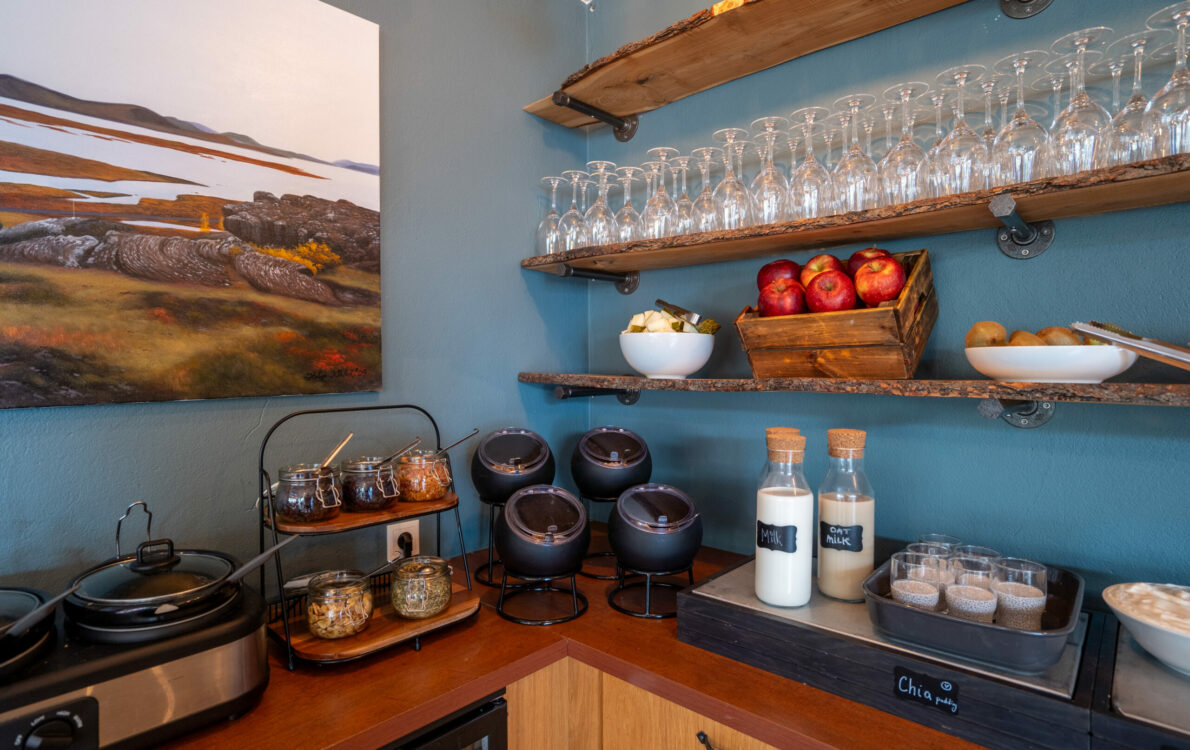 Hotel breakfast buffet with wooden shelves, glasses, fruit and drinks, Hótel Breiðdalsvík