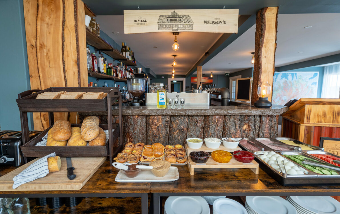 Cosy restaurant and bar interior at Hótel Breiðdalsvík with food display and warm lighting
