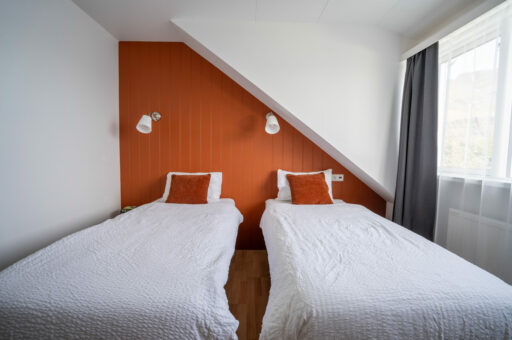 Cosy orange twin bedroom with two single beds, Hótel Breiðdalsvík East Iceland