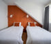 Cosy orange twin bedroom with two single beds, Hótel Breiðdalsvík East Iceland