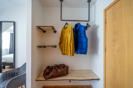 Hotel room wardrobe with yellow and blue coats, Hótel Breiðdalsvík East Iceland